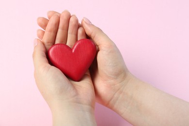 Photo of Woman holding red heart on pink background, closeup