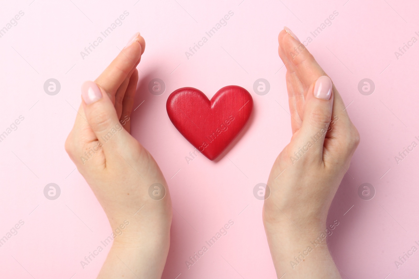 Photo of Woman with red heart on pink background, top view