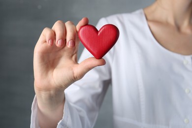 Photo of Doctor holding red heart on grey background, closeup