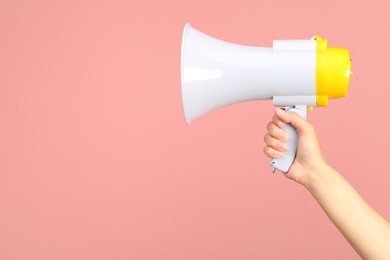 Photo of Woman holding megaphone speaker on pink background, closeup. Space for text