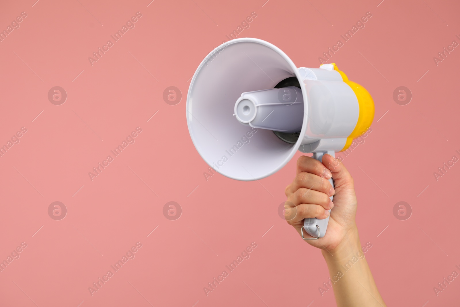 Photo of Woman holding megaphone speaker on pink background, closeup. Space for text