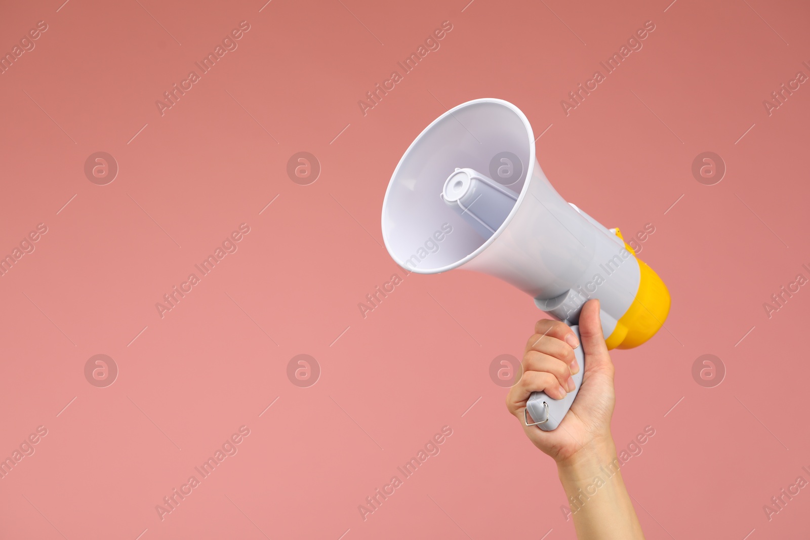 Photo of Woman holding megaphone speaker on pink background, closeup. Space for text