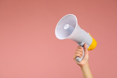 Woman holding megaphone speaker on pink background, closeup. Space for text