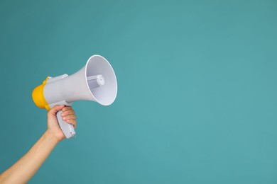 Photo of Woman holding megaphone speaker on blue background, closeup. Space for text