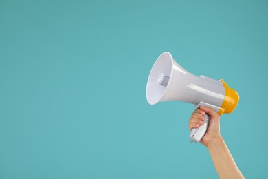 Photo of Woman holding megaphone speaker on blue background, closeup. Space for text