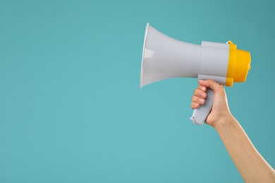 Photo of Woman holding megaphone speaker on blue background, closeup. Space for text