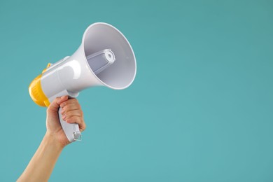 Photo of Woman holding megaphone speaker on blue background, closeup. Space for text