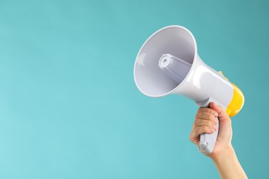 Photo of Woman holding megaphone speaker on blue background, closeup. Space for text