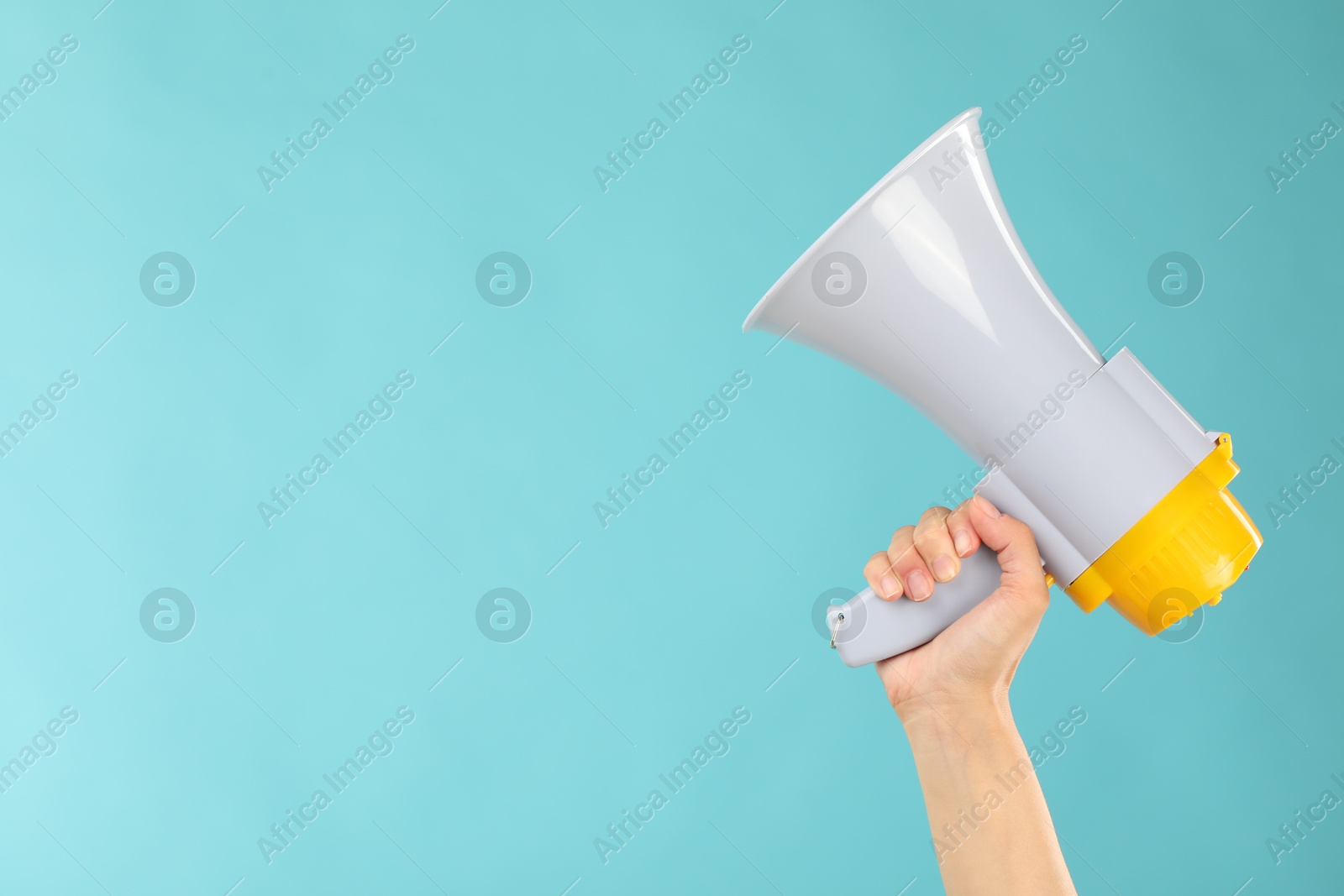 Photo of Woman holding megaphone speaker on blue background, closeup. Space for text