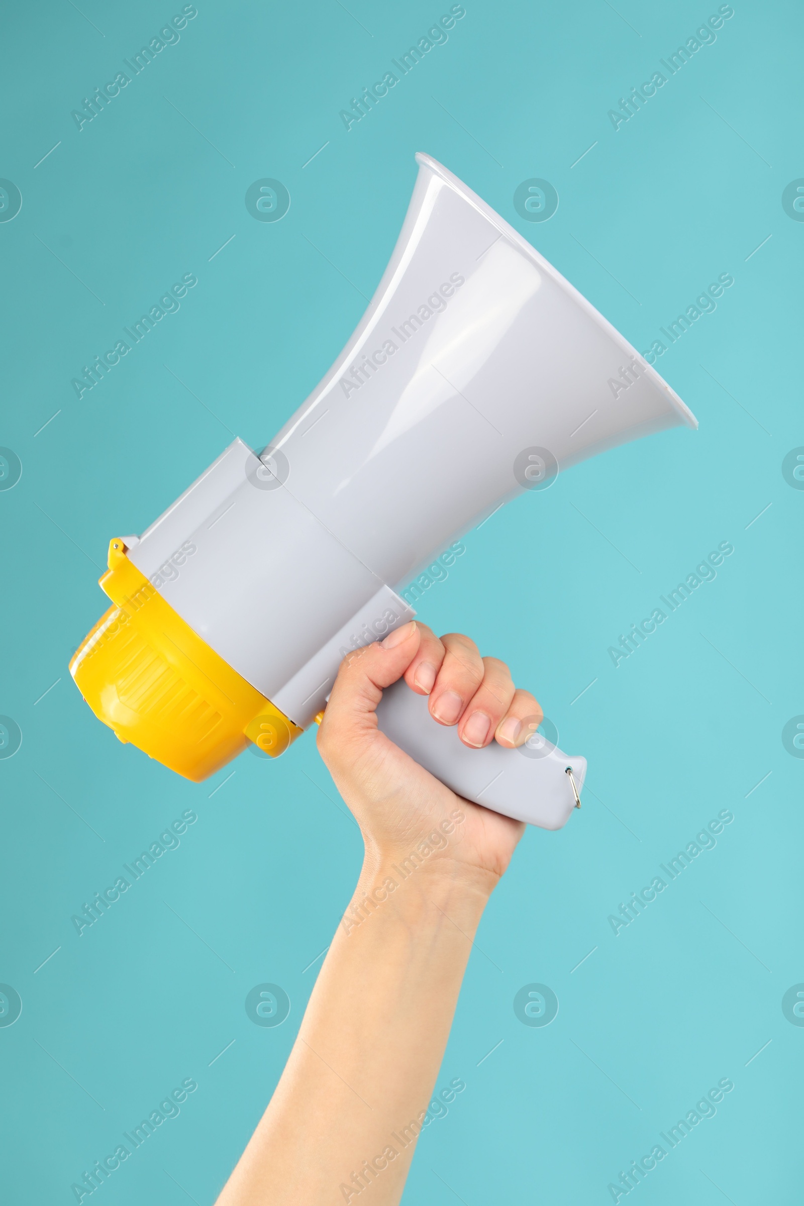 Photo of Woman holding megaphone speaker on blue background, closeup