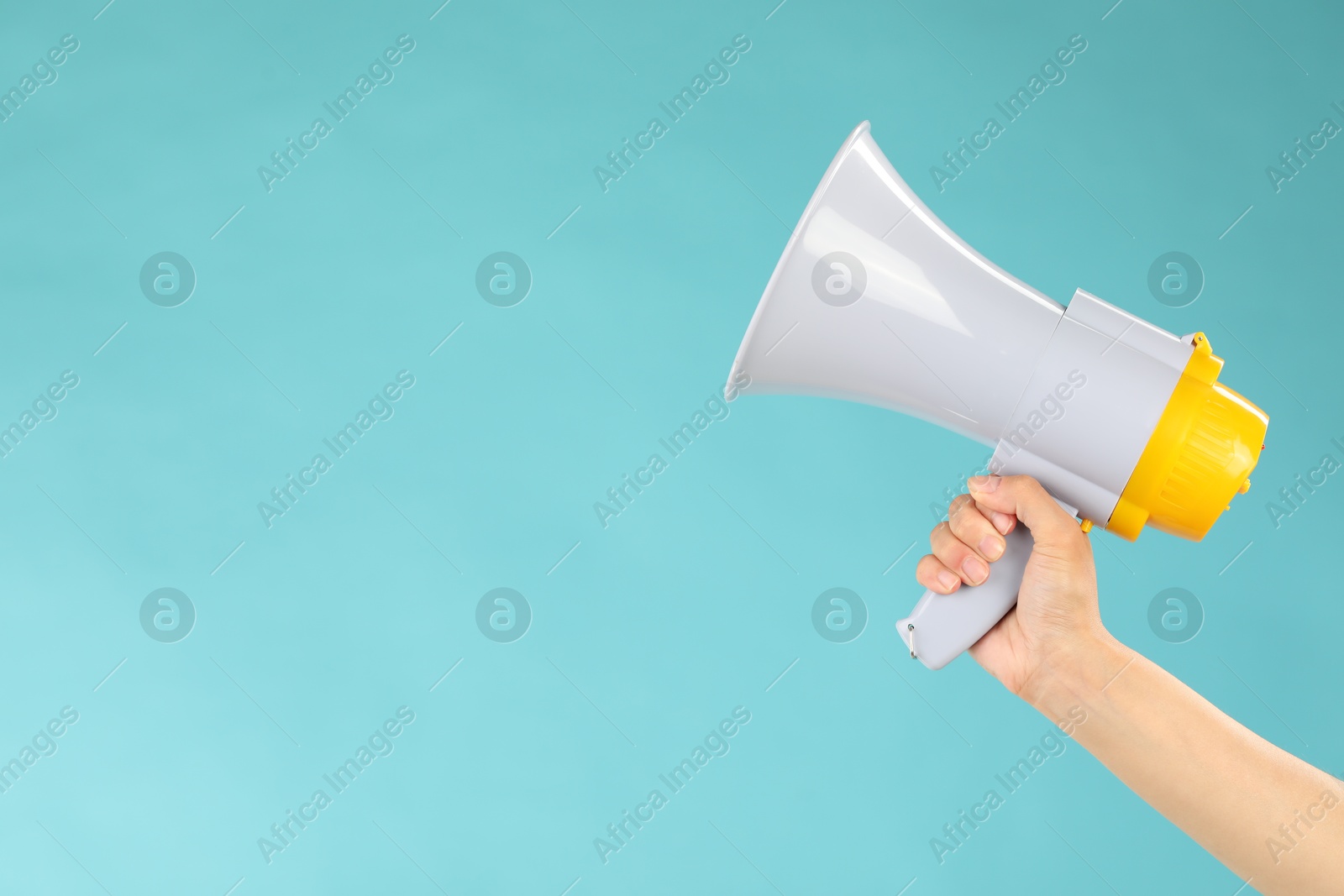 Photo of Woman holding megaphone speaker on blue background, closeup. Space for text