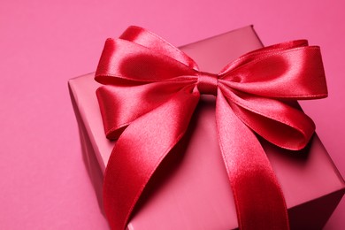 Photo of Gift box with bow on pink background