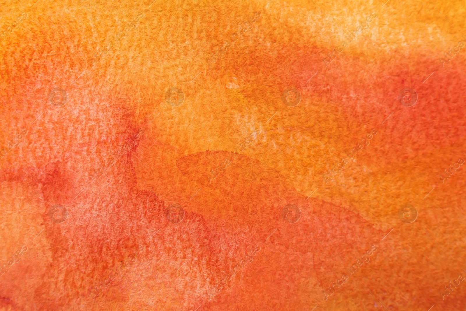 Photo of Orange watercolor painting on paper, top view