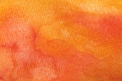 Orange watercolor painting on paper, top view