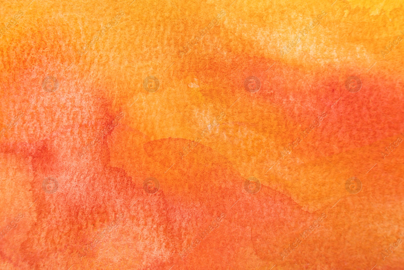 Photo of Orange watercolor painting on paper, top view