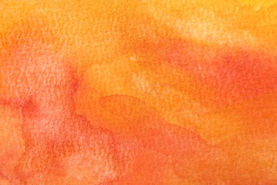 Photo of Orange watercolor painting on paper, top view