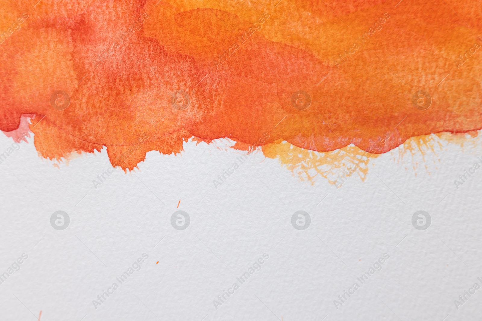 Photo of Orange watercolor painting on white paper, top view. Space for text