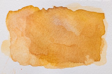 Orange watercolor painting on white paper, top view