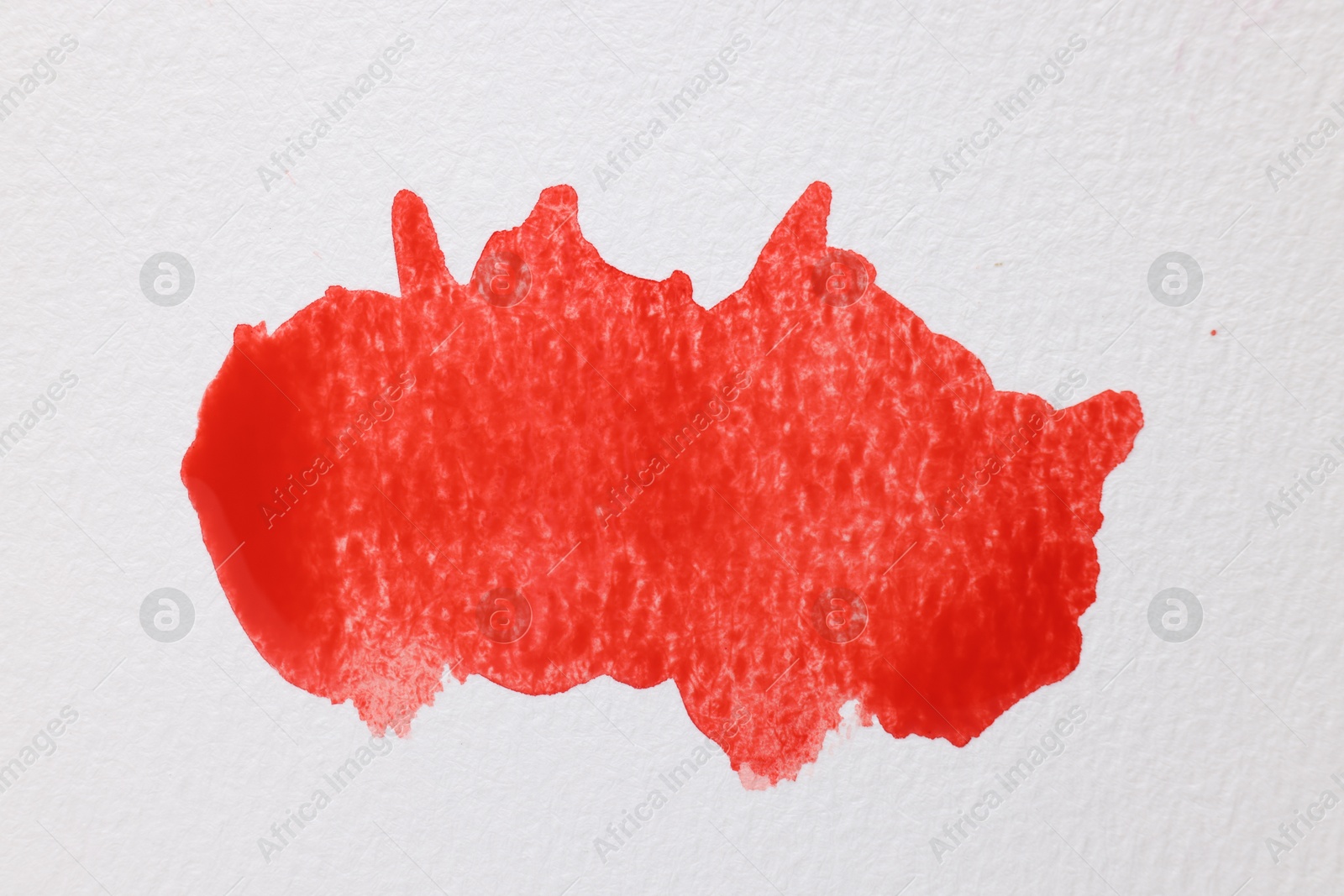 Photo of Red watercolor painting on white paper, top view