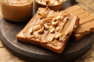 Delicious sandwiches with peanut butter and fresh nuts on wooden table, closeup