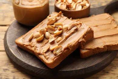 Delicious sandwiches with peanut butter and fresh nuts on wooden table, closeup