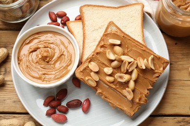 Photo of Delicious sandwich with peanut butter and fresh nuts on wooden table, flat lay