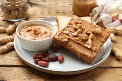 Photo of Delicious sandwich with peanut butter and fresh nuts on wooden table, closeup