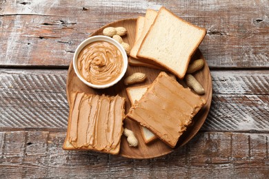 Delicious sandwiches with peanut butter and fresh nuts on wooden table, top view