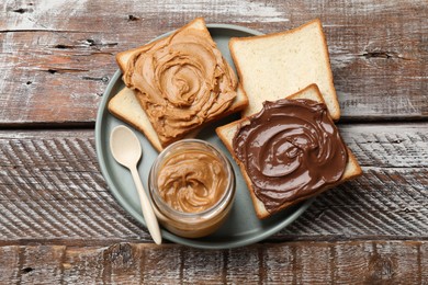 Photo of Delicious sandwiches with peanut butter and chocolate paste on wooden table, top view