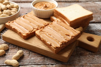 Delicious sandwiches with peanut butter and fresh nuts on wooden table, closeup