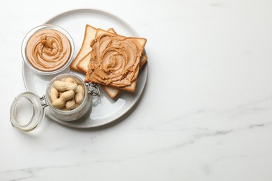 Photo of Delicious sandwich with peanut butter and fresh nuts on white marble table, top view. Space for text