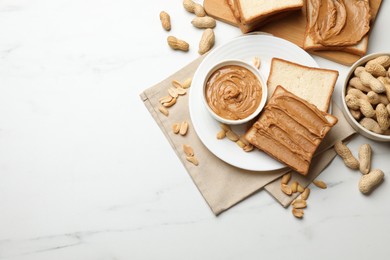 Delicious sandwiches with peanut butter and fresh nuts on white marble table, flat lay. Space for text