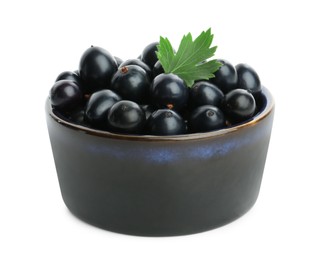 Photo of Bowl of ripe blackcurrants and green leaf isolated on white