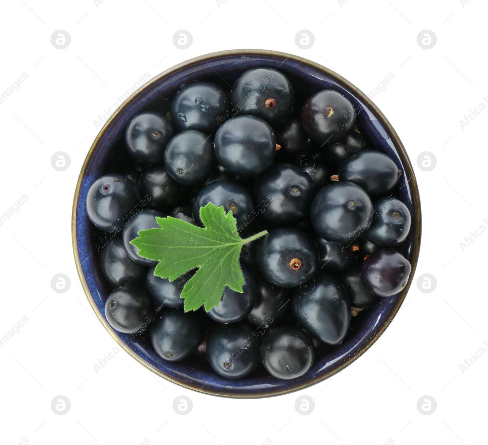 Photo of Bowl of ripe blackcurrants and green leaf isolated on white, top view