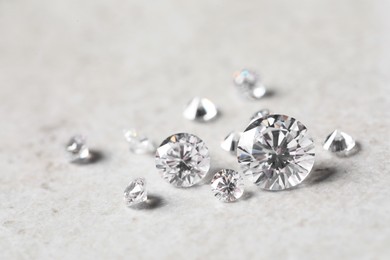 Photo of Many beautiful shiny diamonds on light background, closeup