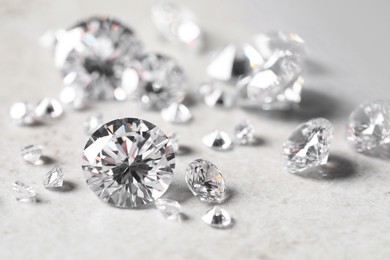 Photo of Many beautiful shiny diamonds on light background, closeup