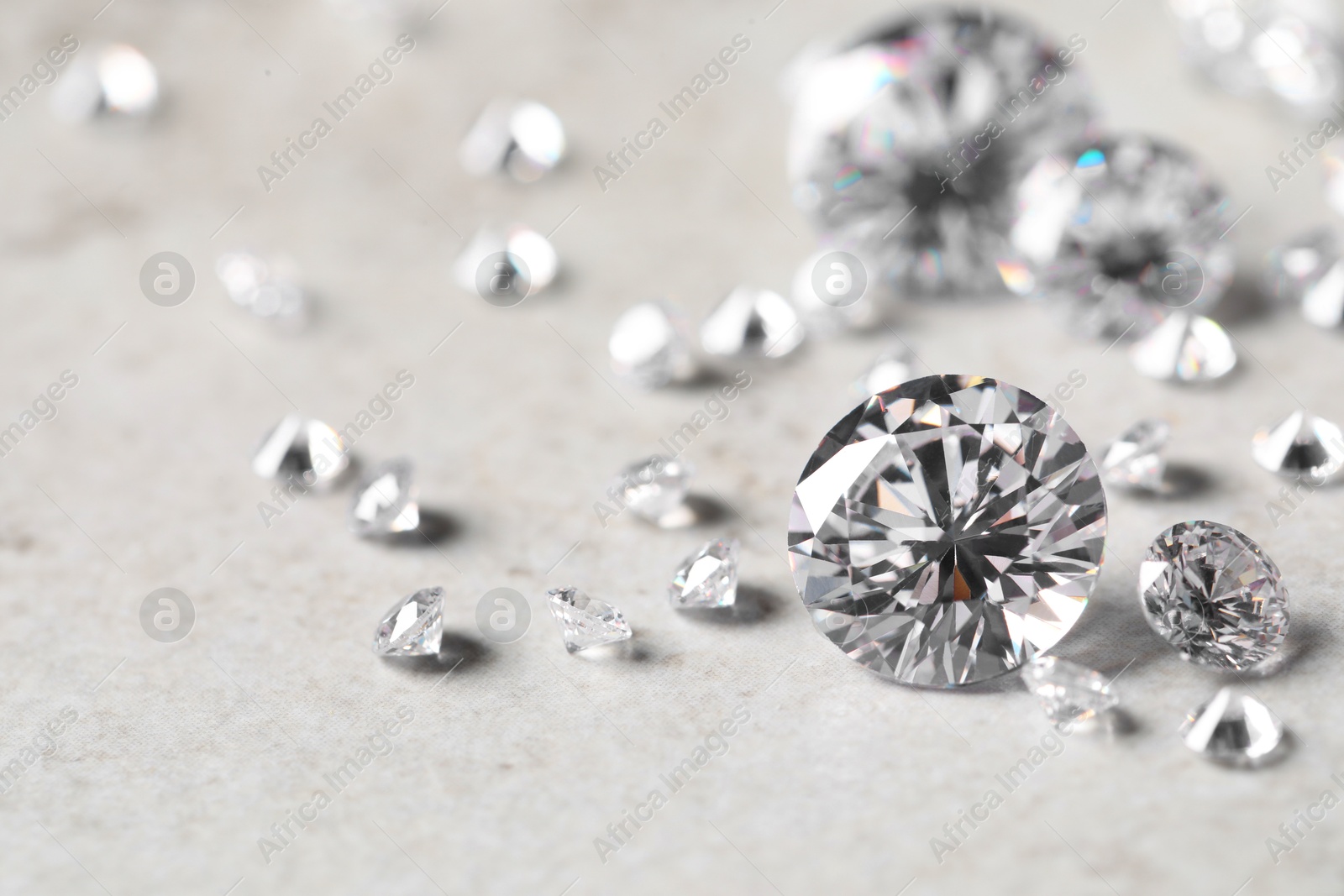 Photo of Many beautiful shiny diamonds on light background, closeup