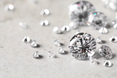 Photo of Many beautiful shiny diamonds on light background, closeup