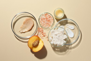 Petri dishes with different cosmetic products and peach on beige background, flat lay