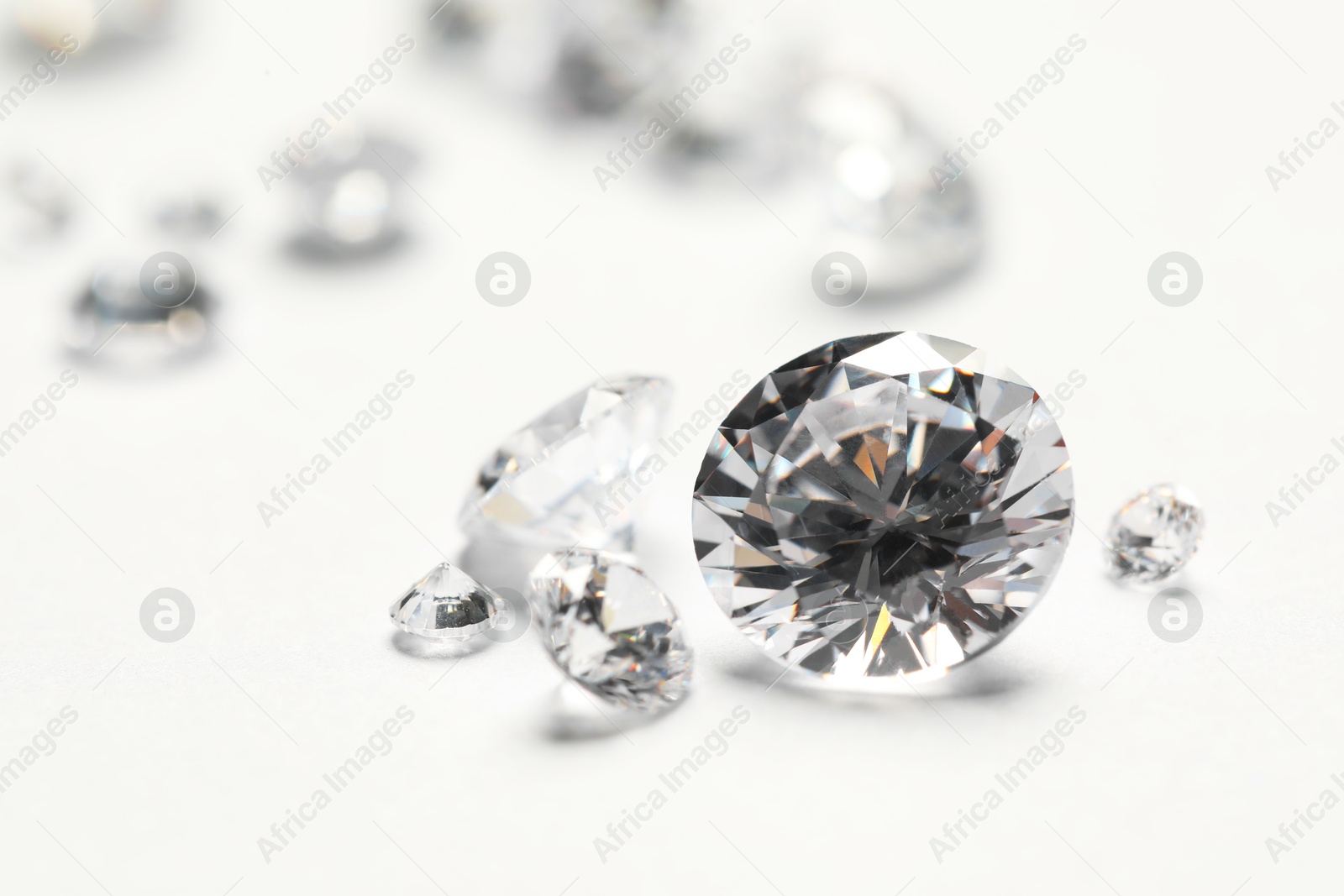 Photo of Many beautiful shiny diamonds on white background, closeup