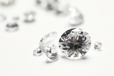 Photo of Many beautiful shiny diamonds on white background, closeup