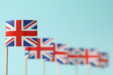 Small paper flags of United Kingdom on light blue background, selective focus. Space for text