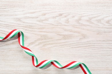 Photo of Ribbon in colors of Hungarian flag on white wooden background, top view. Space for text