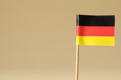 Small paper flag of Germany on beige background. Space for text