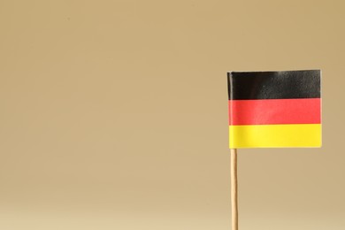 Small paper flag of Germany on beige background. Space for text