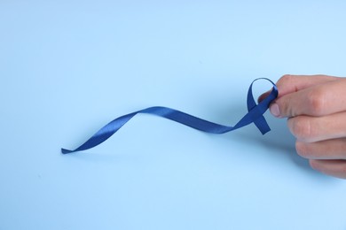 Photo of Prostate cancer awareness. Man with light blue ribbon as symbol of support on color background