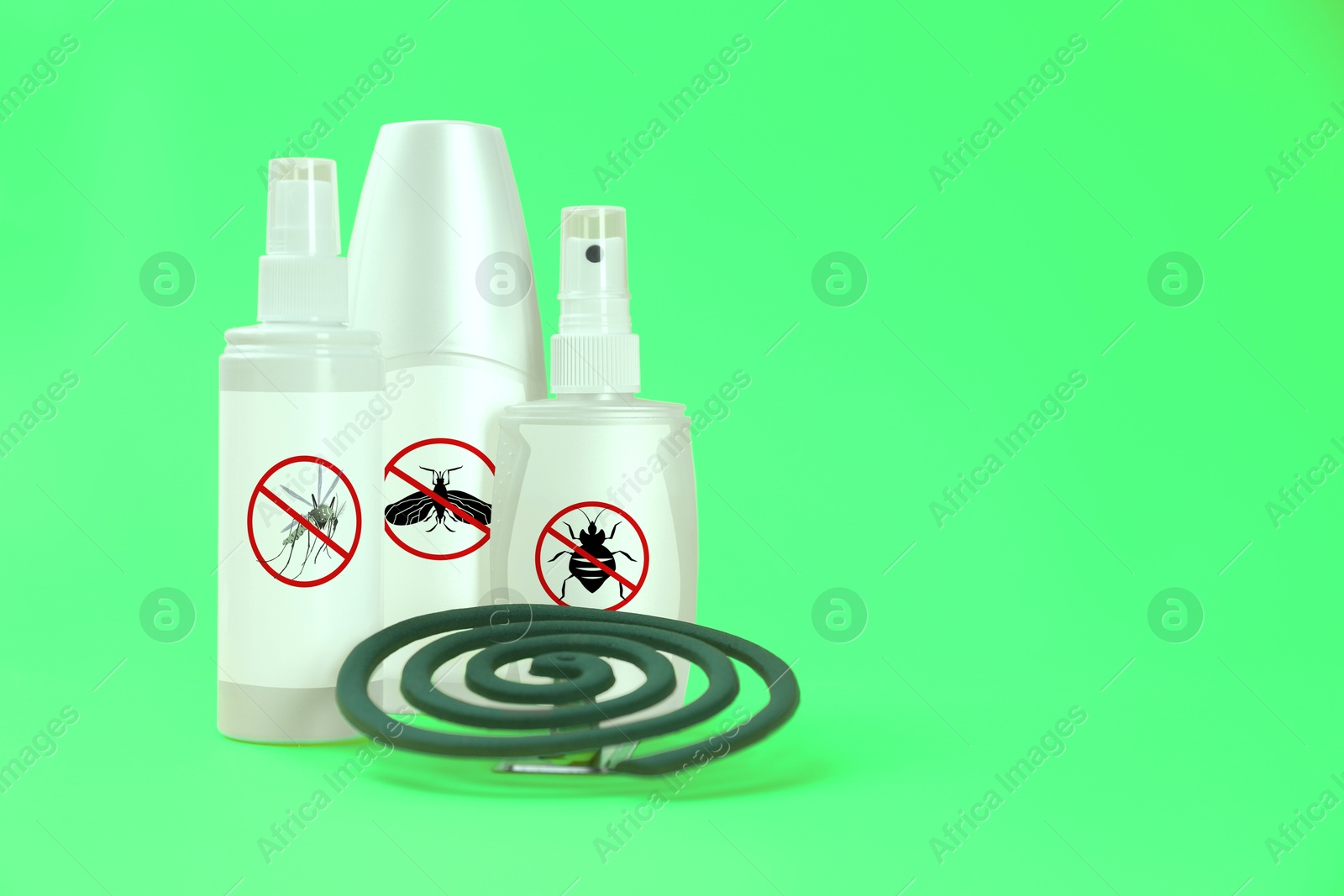 Image of Mosquito coil and other insect repellents on green background, space for text