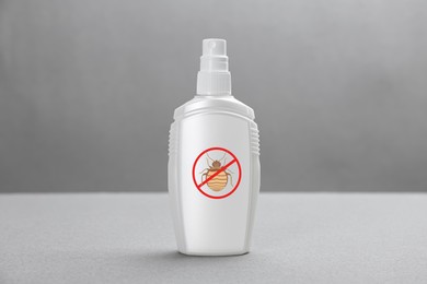 Insect repellent in spray bottle on grey background