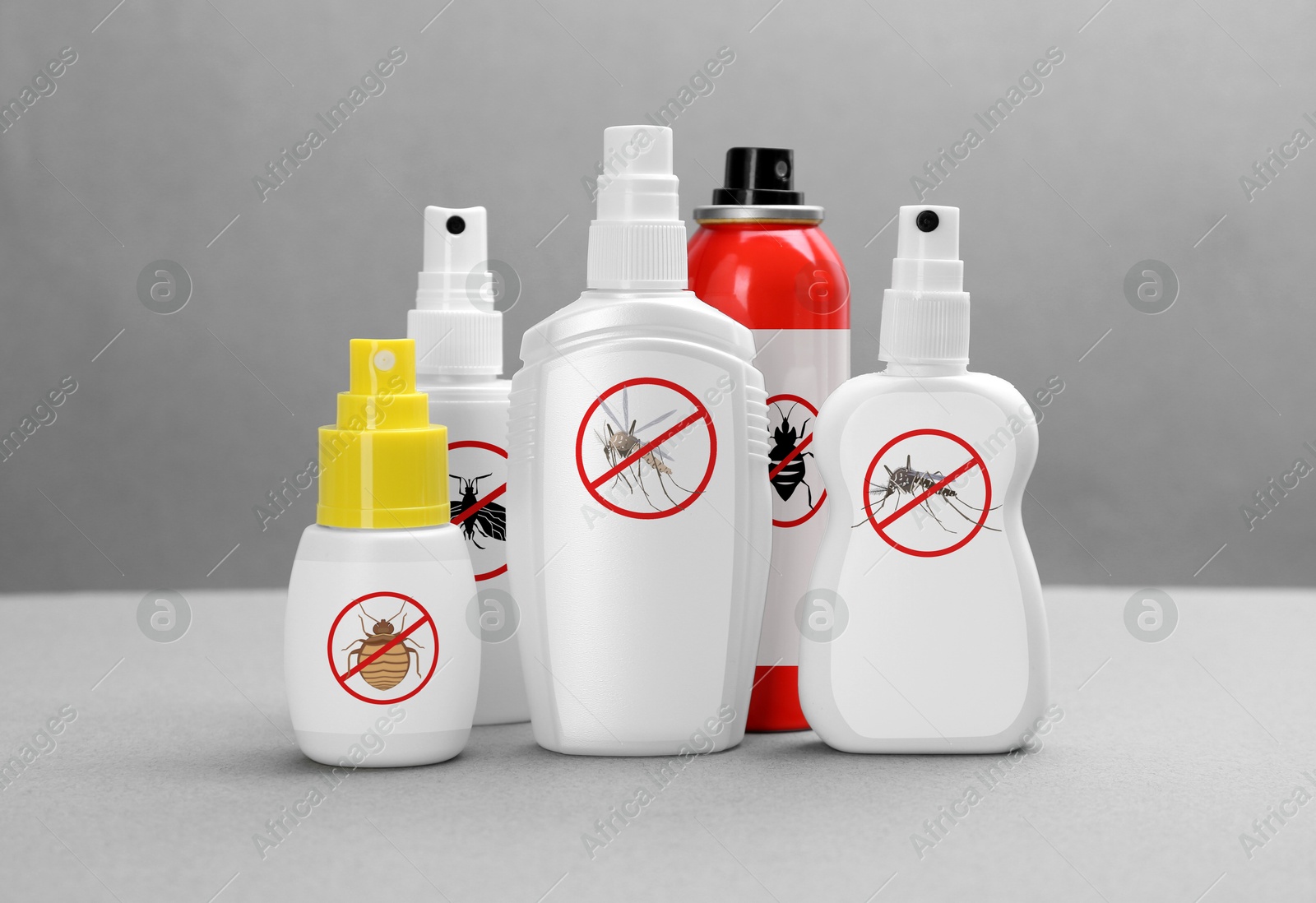 Image of Different insect repellents in spray bottles on grey background