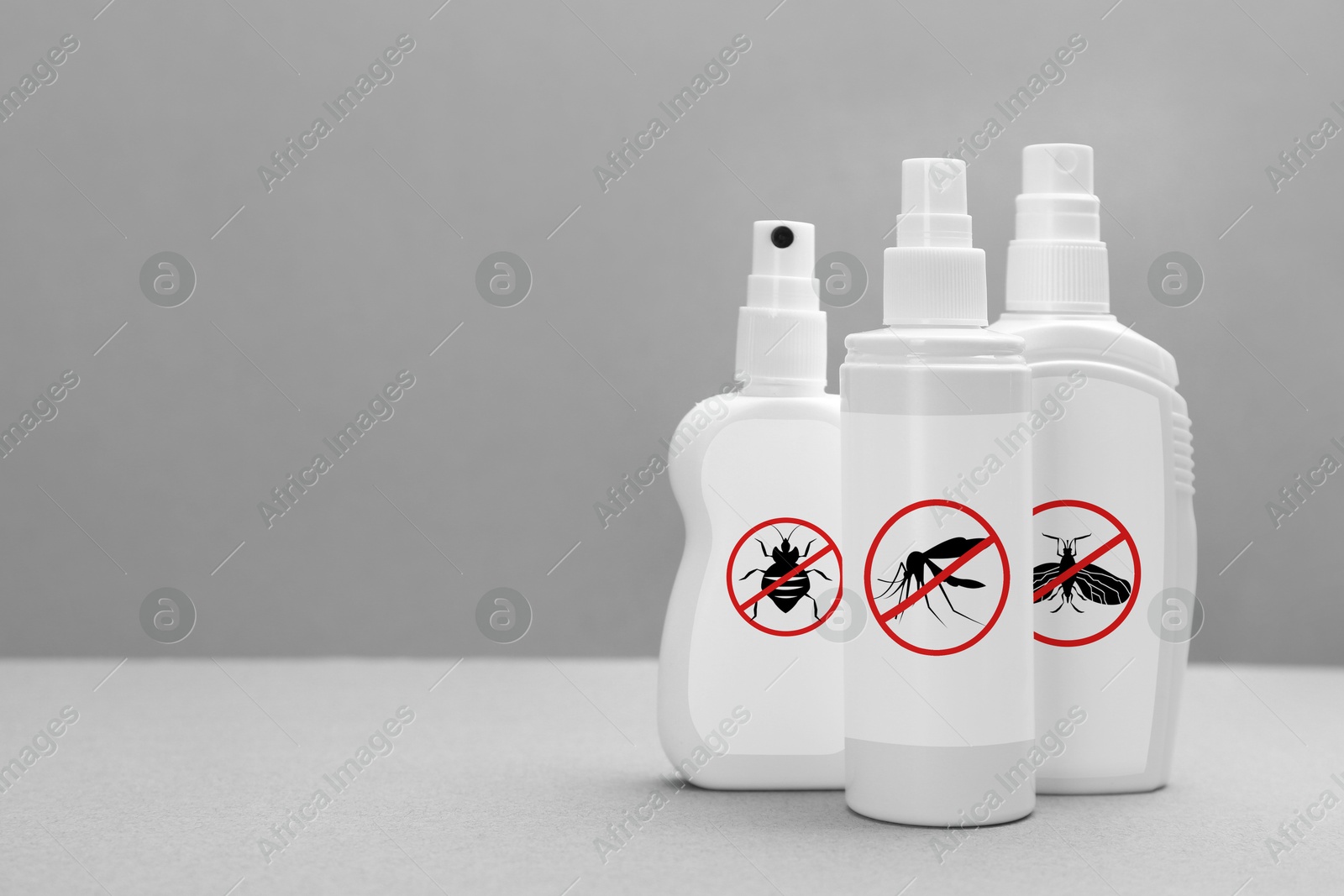 Image of Different insect repellents in spray bottles on grey background, space for text